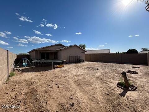 7664 W Vermont Ave, Glendale, AZ 85303 - rear view of property featuring a trampoline and a fenced backyard