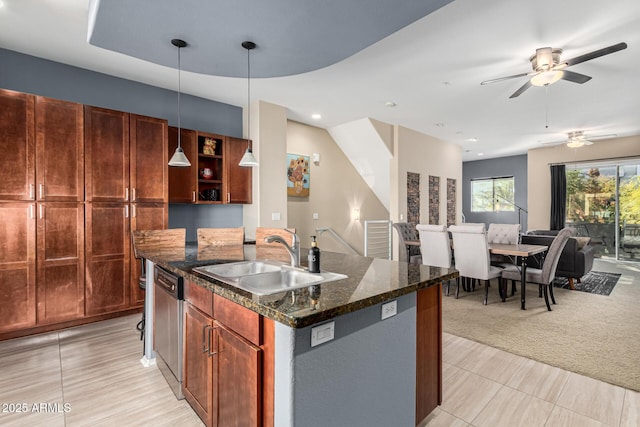 kitchen featuring sink, hanging light fixtures, a kitchen island with sink, stainless steel dishwasher, and light colored carpet