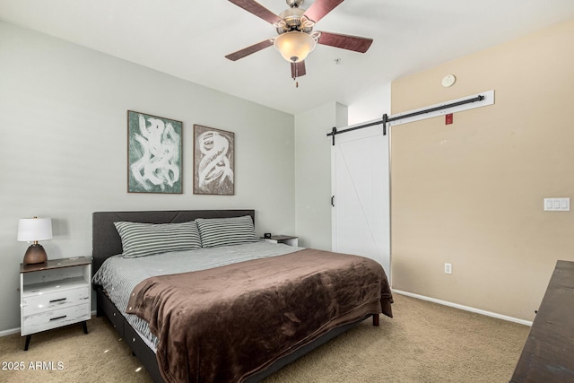 carpeted bedroom featuring ceiling fan and a barn door