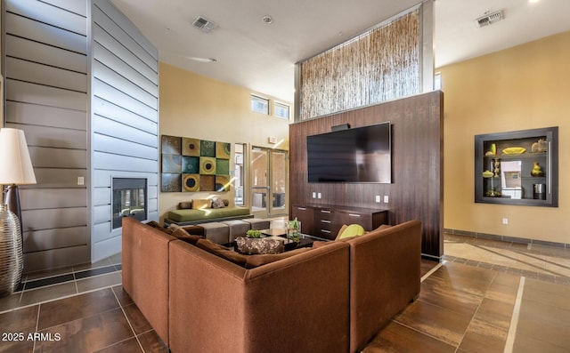 living room featuring a high ceiling and dark tile patterned flooring