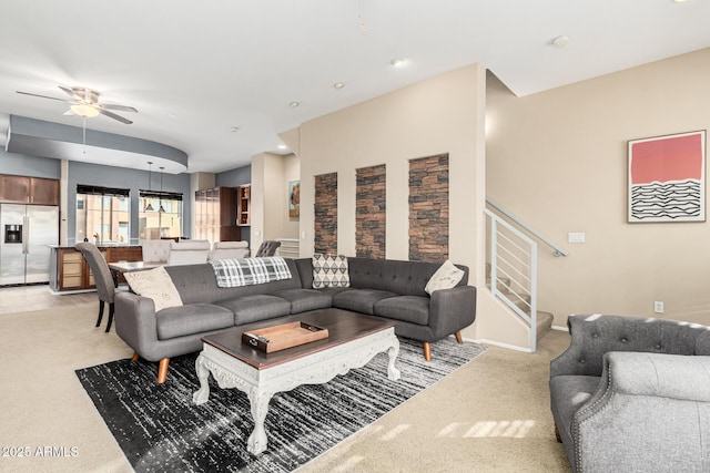 living room featuring light colored carpet and ceiling fan