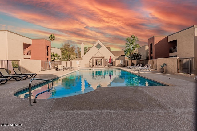 pool at dusk with a patio