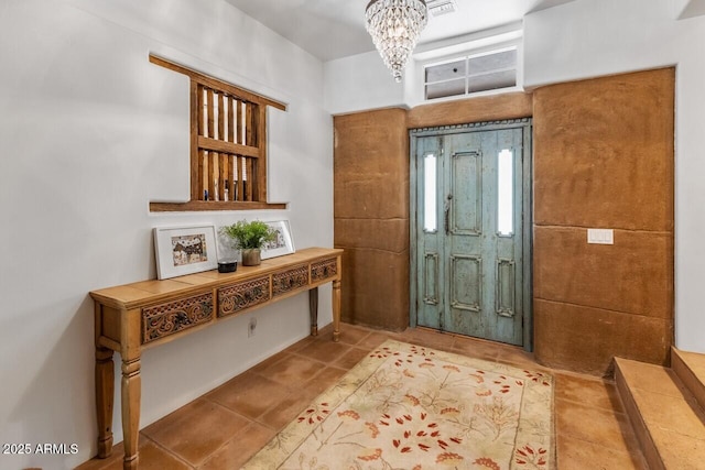 tiled entryway with an inviting chandelier