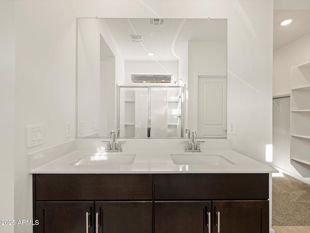 bathroom with double vanity, a sink, and visible vents