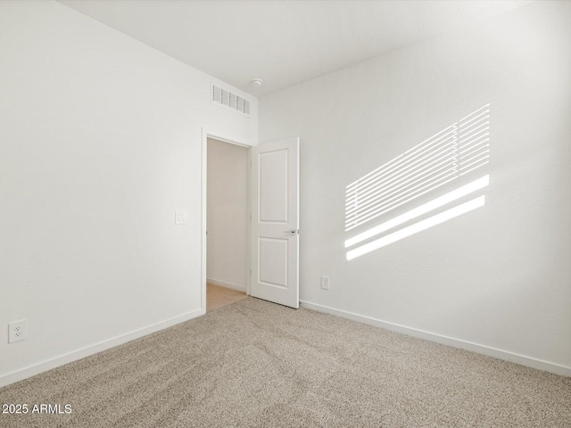 unfurnished room featuring baseboards, visible vents, and carpet flooring