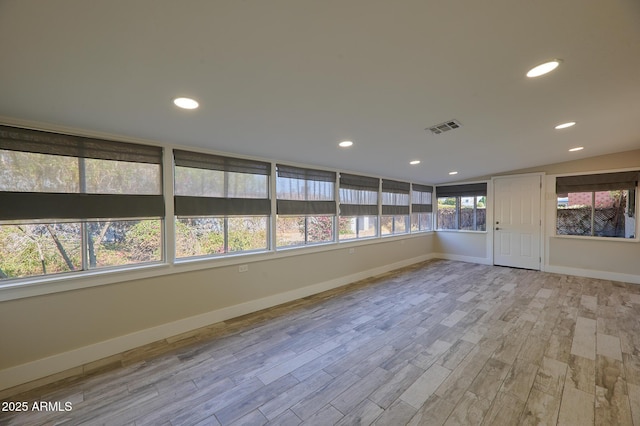 unfurnished room featuring vaulted ceiling and light wood-type flooring