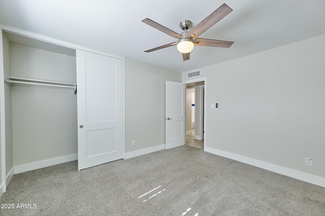 unfurnished bedroom featuring light colored carpet, a closet, and ceiling fan