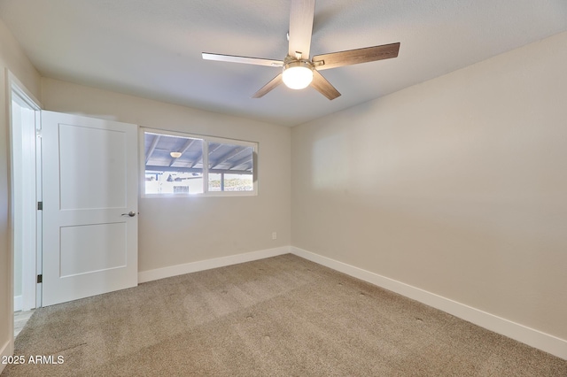 carpeted spare room featuring ceiling fan