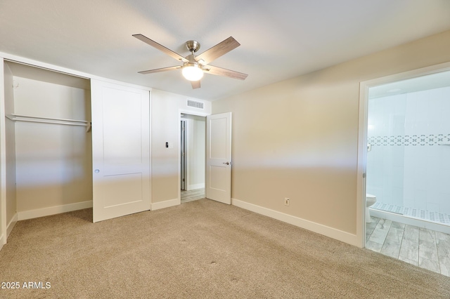 unfurnished bedroom with light carpet, connected bathroom, and ceiling fan