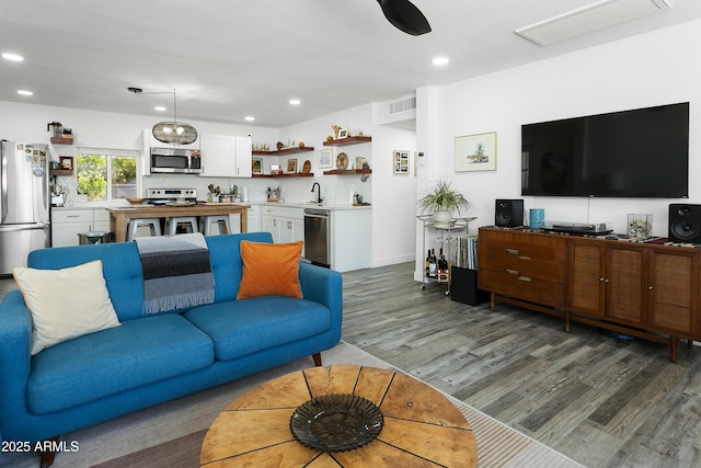 912 E Orchid Ln, Phoenix, AZ 85020 - living area featuring wood finished floors, bar with sink, and recessed lighting