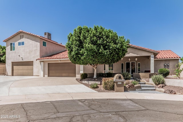 mediterranean / spanish home featuring a garage, stucco siding, concrete driveway, and a tile roof