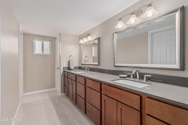 bathroom with double vanity, baseboards, and a sink