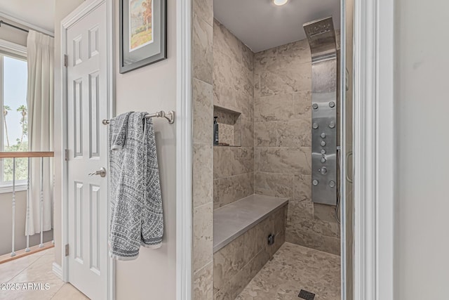 full bath featuring tile patterned floors, a tile shower, and a healthy amount of sunlight