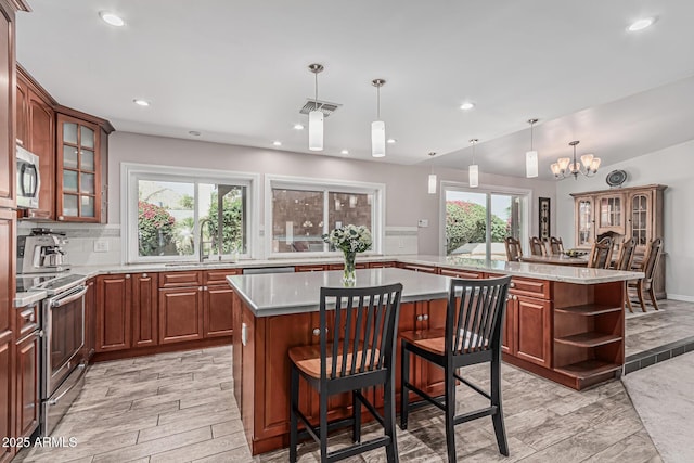 kitchen with open shelves, a sink, a center island, stainless steel appliances, and visible vents