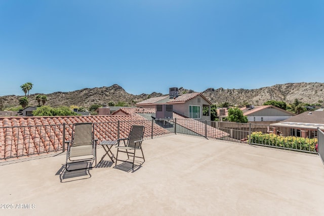 view of patio / terrace with fence and a mountain view