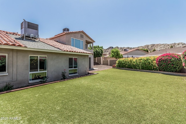 view of yard featuring central AC unit, a mountain view, and fence