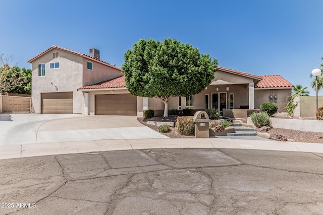mediterranean / spanish home with an attached garage, stucco siding, central air condition unit, a tiled roof, and driveway
