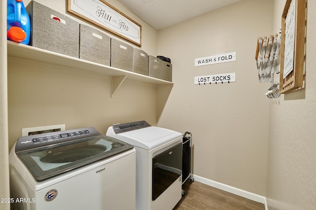 laundry room with separate washer and dryer and hardwood / wood-style flooring