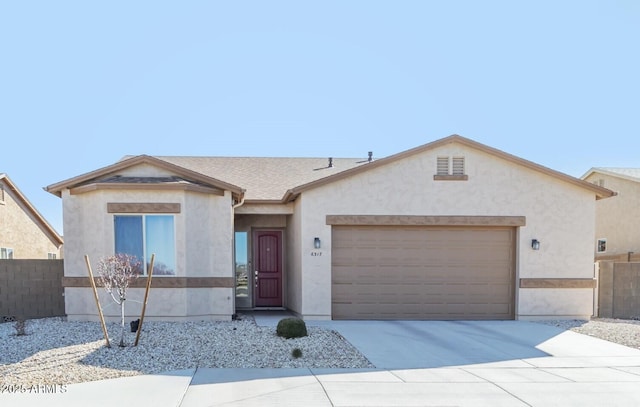 view of front of house with an attached garage, fence, concrete driveway, roof with shingles, and stucco siding