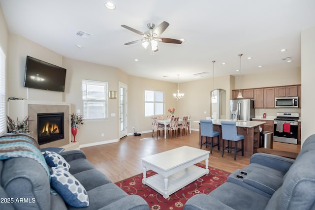 living area with light wood-style floors, recessed lighting, visible vents, and baseboards