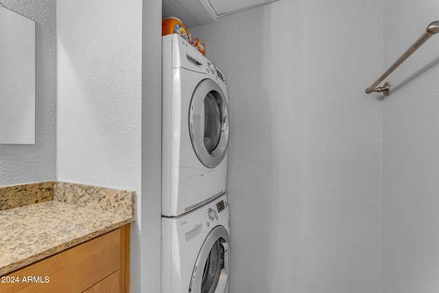 washroom featuring stacked washer / drying machine