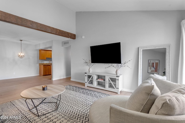 living room featuring beamed ceiling, light hardwood / wood-style floors, and high vaulted ceiling