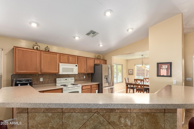 kitchen with lofted ceiling, hanging light fixtures, white appliances, and decorative backsplash