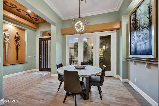 dining area featuring baseboards, ornamental molding, and light wood-type flooring