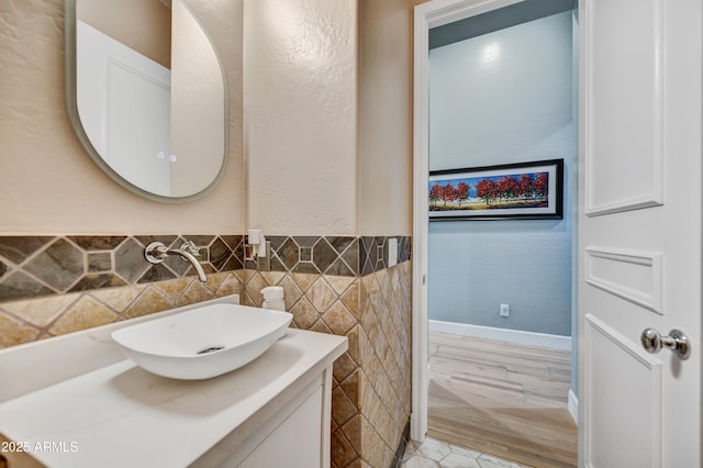 bathroom featuring vanity, a wainscoted wall, and tile walls