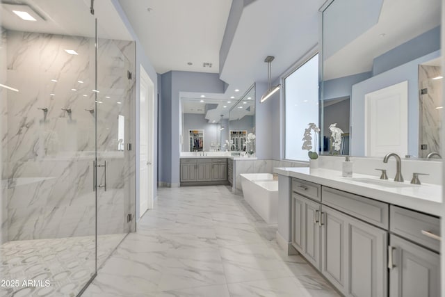 bathroom with a sink, a marble finish shower, a garden tub, and marble finish floor