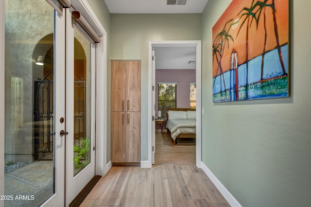 hall featuring french doors, baseboards, visible vents, and wood finished floors