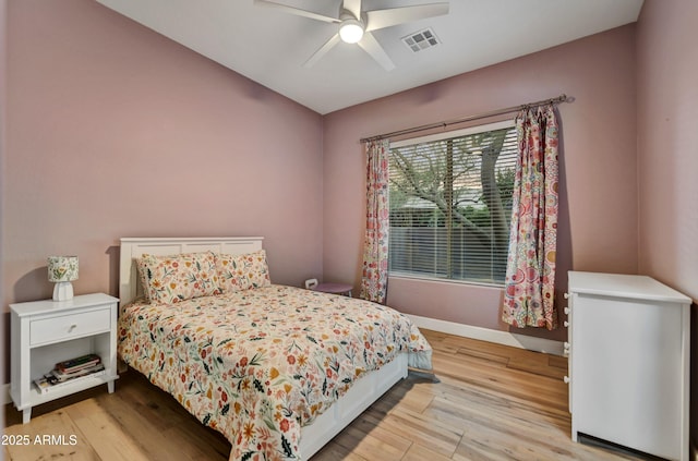 bedroom with light wood-style floors, baseboards, ceiling fan, and visible vents