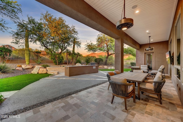 view of patio / terrace featuring an outdoor kitchen, outdoor dining area, and a fenced backyard