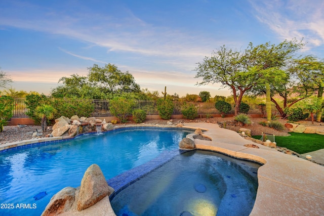view of pool featuring a fenced backyard and a pool with connected hot tub