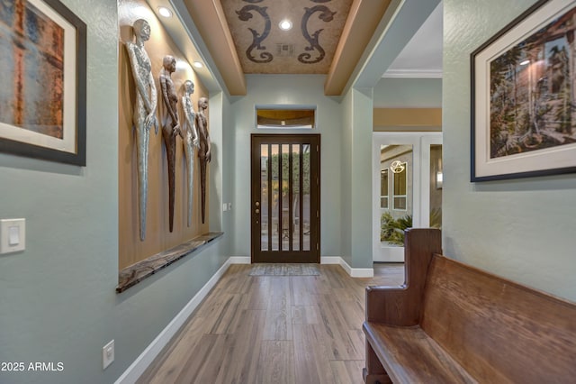 foyer with baseboards and wood finished floors