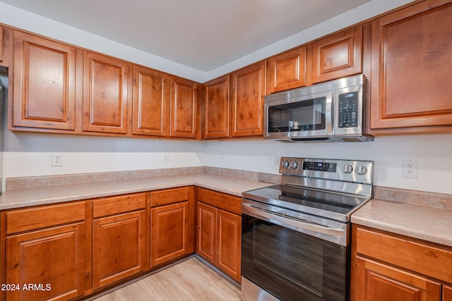 kitchen featuring appliances with stainless steel finishes and light hardwood / wood-style floors