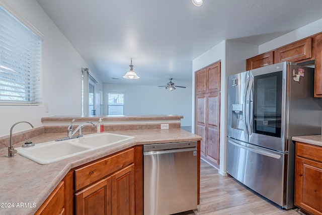 kitchen with sink, appliances with stainless steel finishes, ceiling fan, light hardwood / wood-style flooring, and pendant lighting