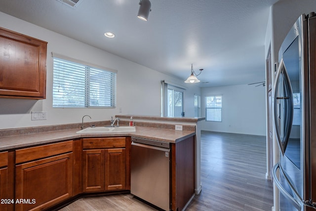 kitchen with a wealth of natural light, light wood-type flooring, appliances with stainless steel finishes, and sink