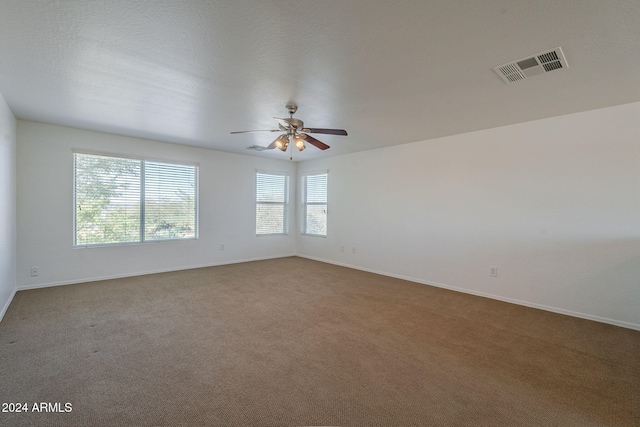 carpeted empty room featuring a textured ceiling and ceiling fan