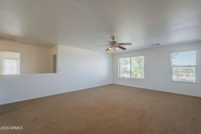 unfurnished room with a textured ceiling, ceiling fan, and carpet floors