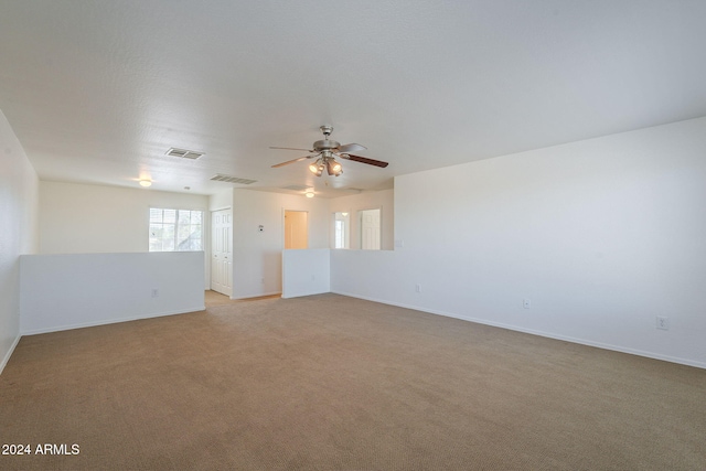 carpeted spare room featuring ceiling fan