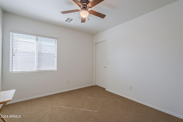 carpeted spare room featuring ceiling fan