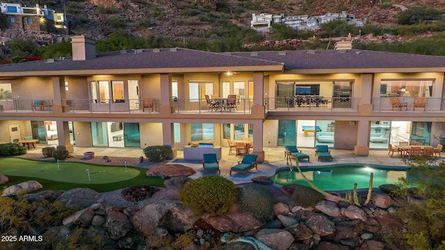 rear view of property with a patio area and a balcony