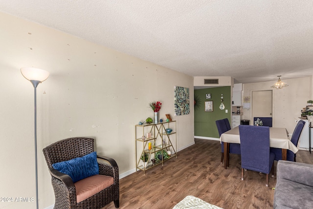 dining space with a textured ceiling and wood-type flooring