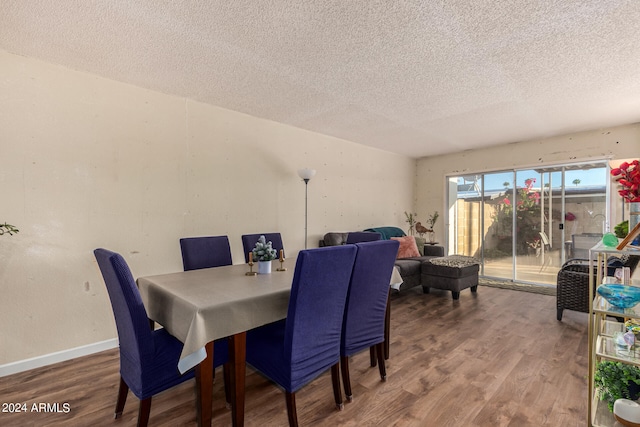 dining area featuring a textured ceiling and wood-type flooring