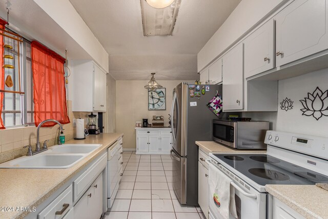 kitchen with appliances with stainless steel finishes, sink, decorative backsplash, and white cabinets