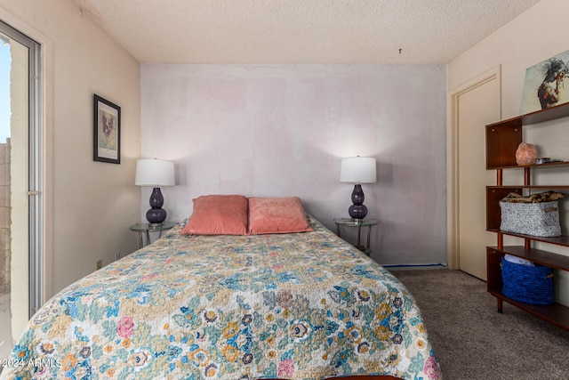 bedroom with a textured ceiling and dark colored carpet