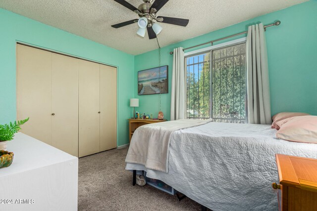 carpeted bedroom featuring a closet, a textured ceiling, and ceiling fan