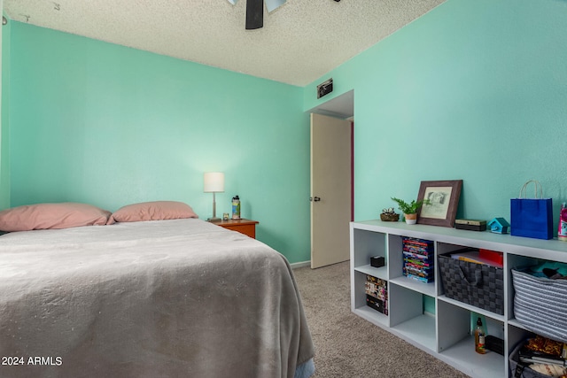 bedroom with ceiling fan, light carpet, and a textured ceiling