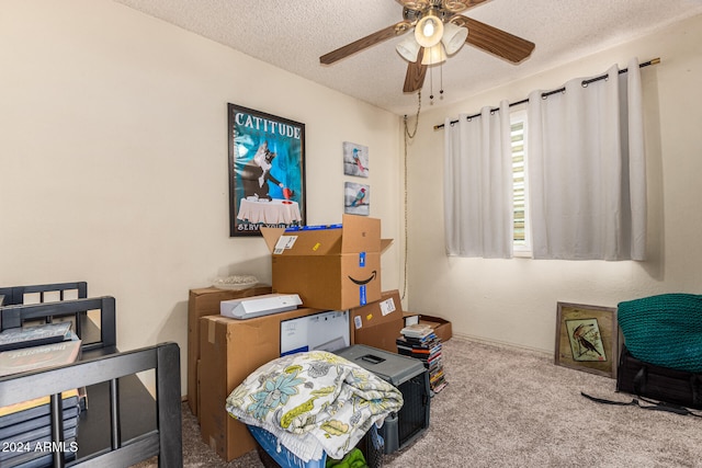 interior space featuring ceiling fan, a textured ceiling, and light colored carpet